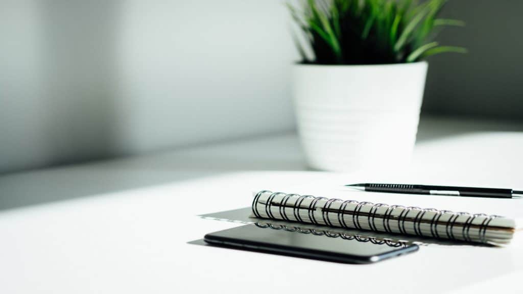 pen, notebook, phone on table