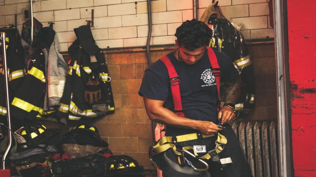 man firefighter with firefighter gear around him