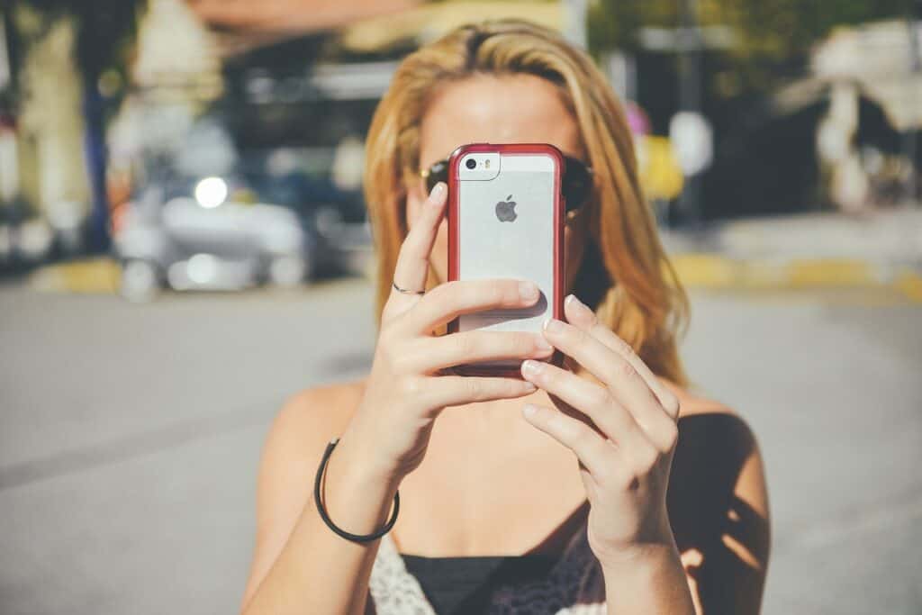 Teen girl face covered by cell phone