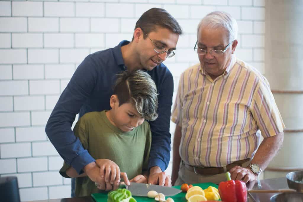 grandpa dad son chopping vegetables in kitchen