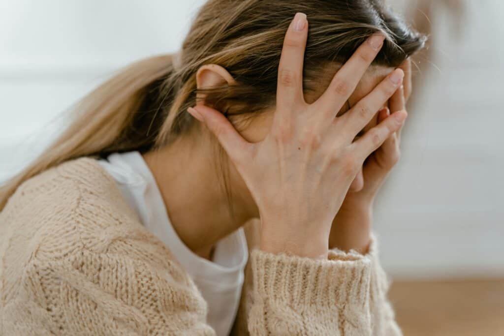 middle aged woman sad ashamed holding face in hands