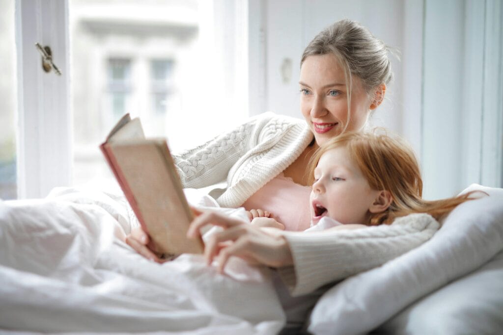 mom and daughter reading in bed