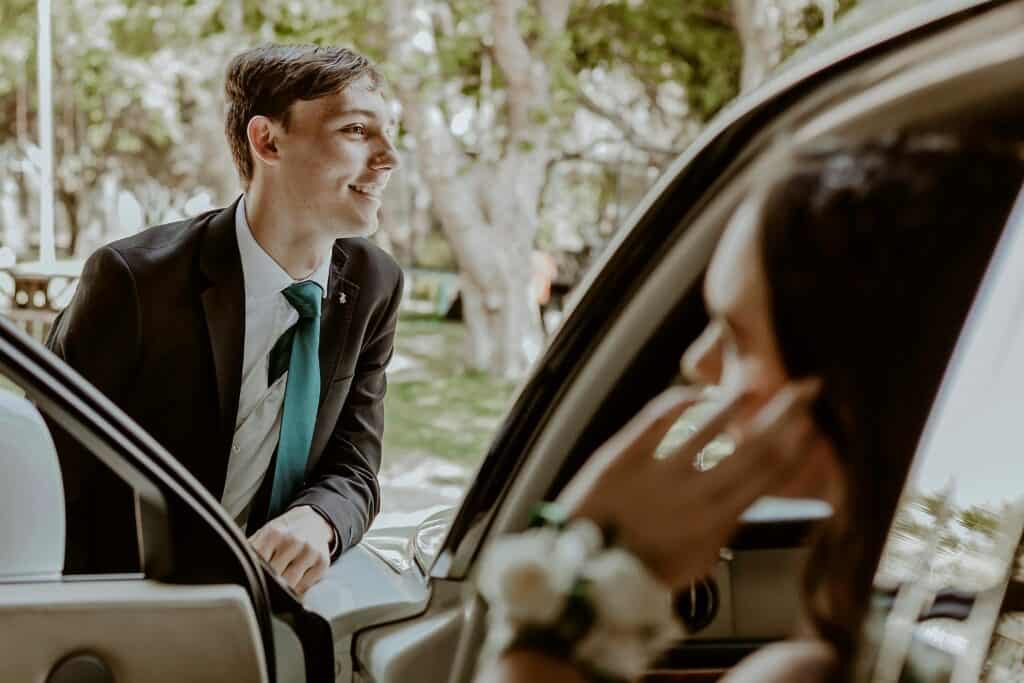 boy tux prom standing in front of car girl inside