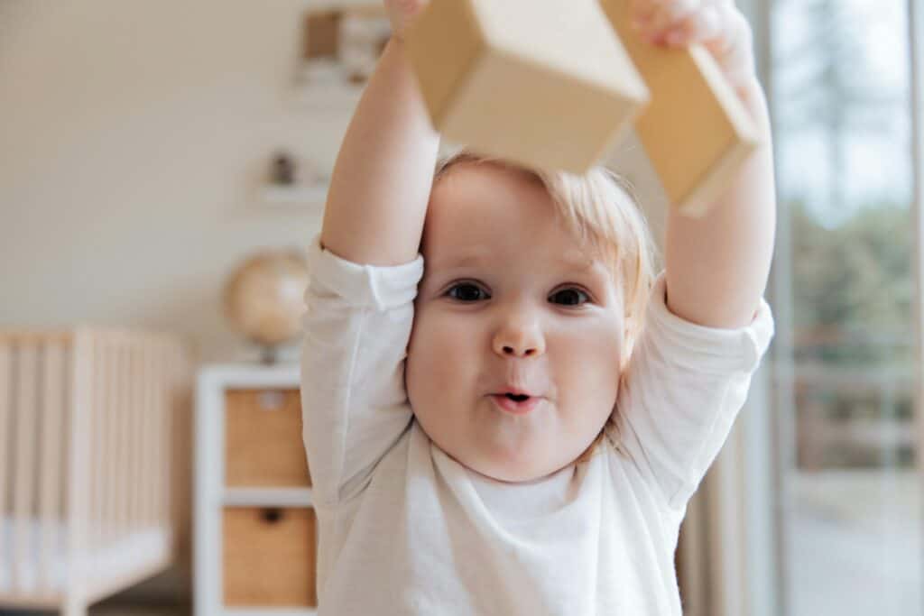 toddler with blocks mouth open