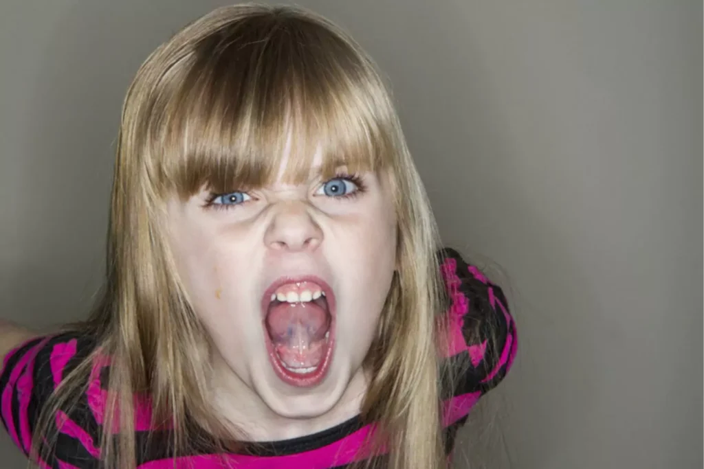 Portrait of a young girl making an angry face
