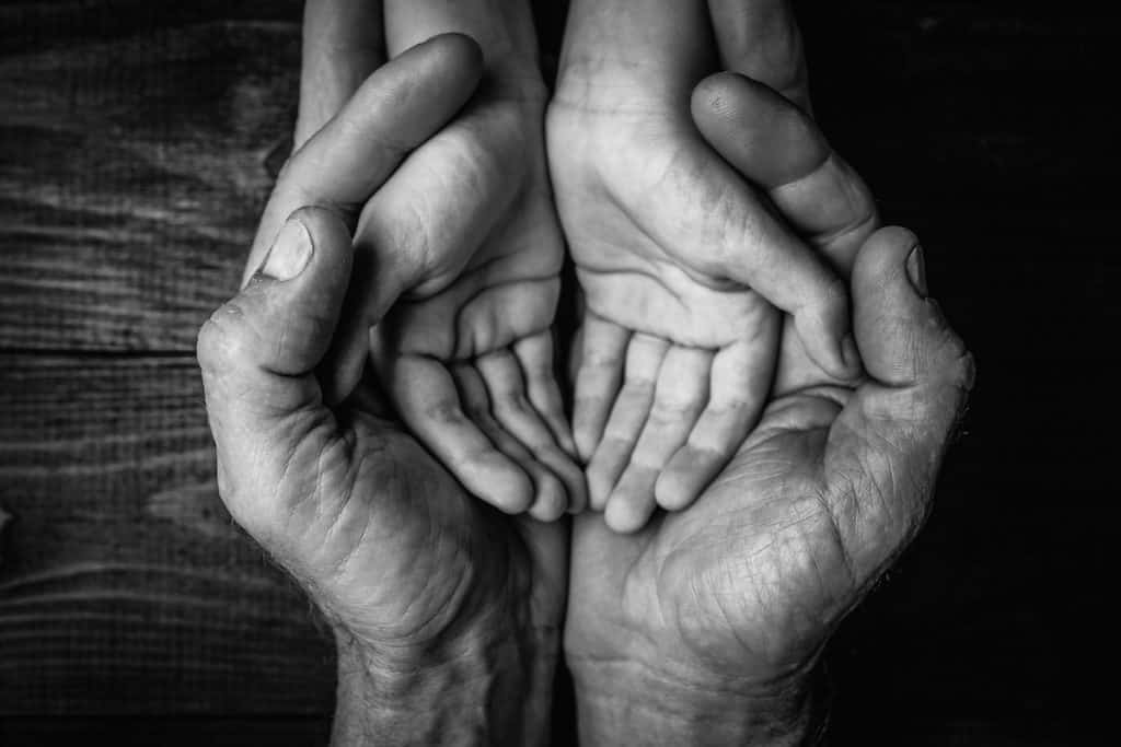 A father holds his child's hands