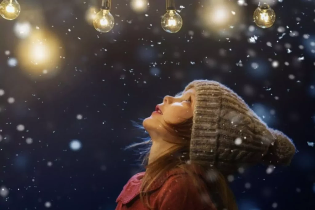 Child looking up at Christmas lights and stars