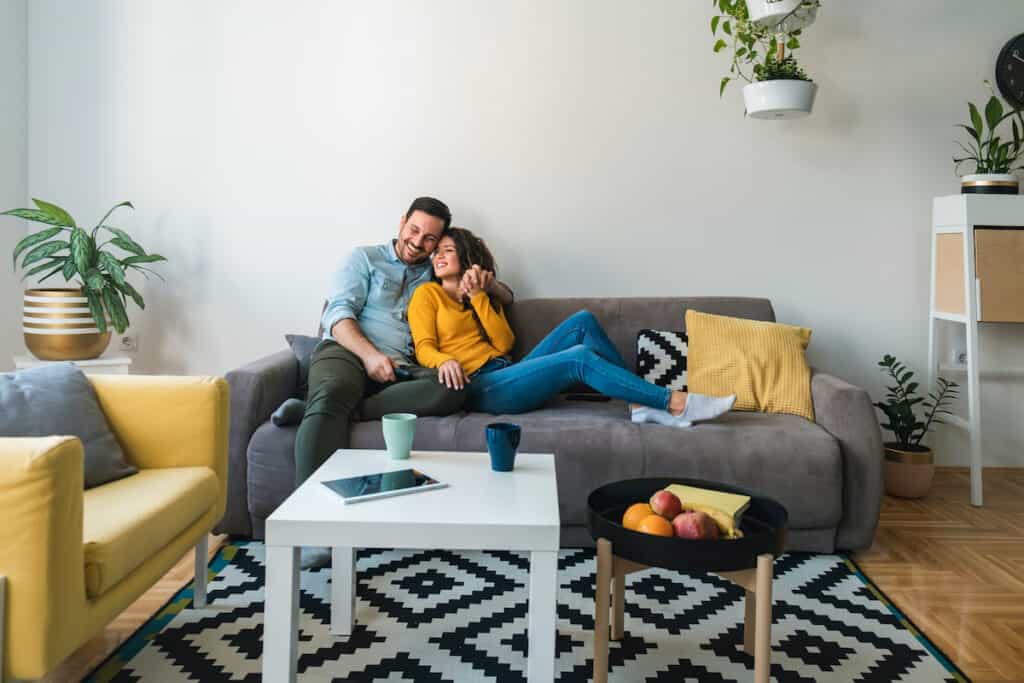 Husband and wife sitting on a couch, supporting each other.