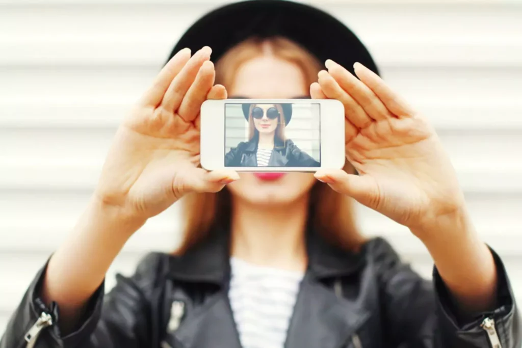 Middle grade girl holding a camera with her photo on the screen