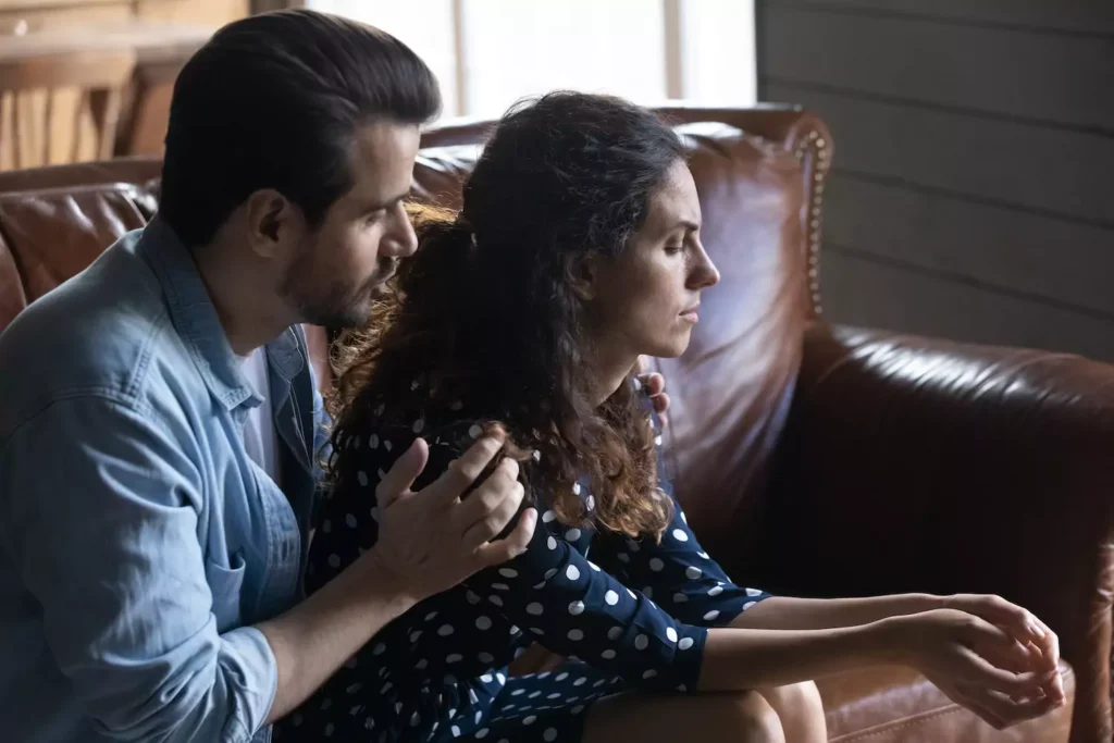 A man comforts his sad wife. Here's how to help a depressed spouse.